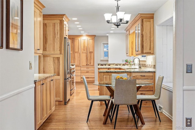 10849 E Crestridge Cir, Englewood, CO 80111 - kitchen with light wood-style flooring, freestanding refrigerator, a chandelier, light stone counters, and light brown cabinets