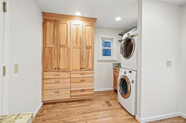 10849 E Crestridge Cir, Englewood, CO 80111 - laundry room featuring estacked washer and dryer, cabinet space, light wood-style floors, baseboards, and recessed lighting