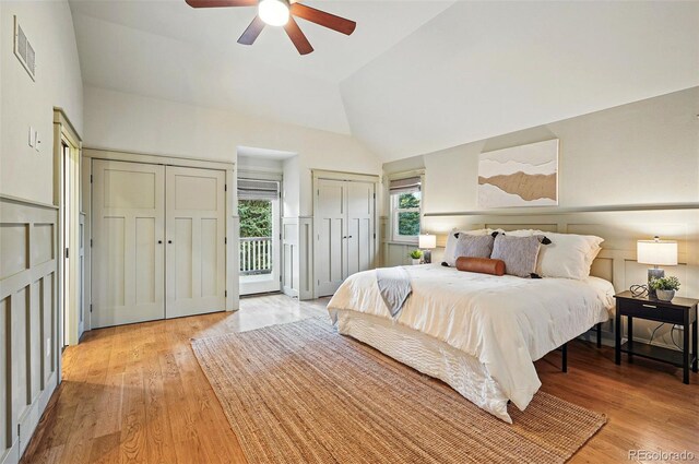 10849 E Crestridge Cir, Englewood, CO 80111 - bedroom with light wood-style floors, high vaulted ceiling, a decorative wall, multiple closets, and wainscoting