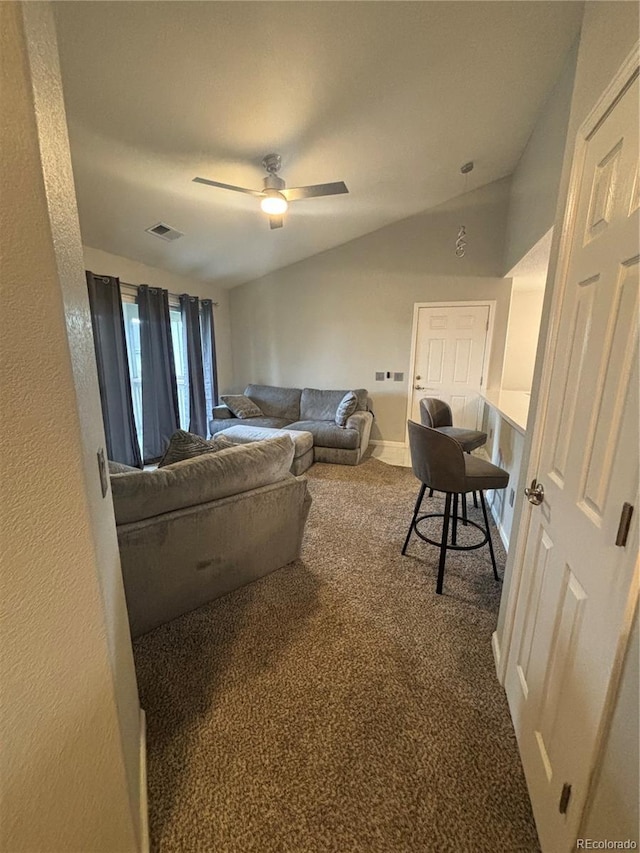 carpeted living room with ceiling fan and lofted ceiling