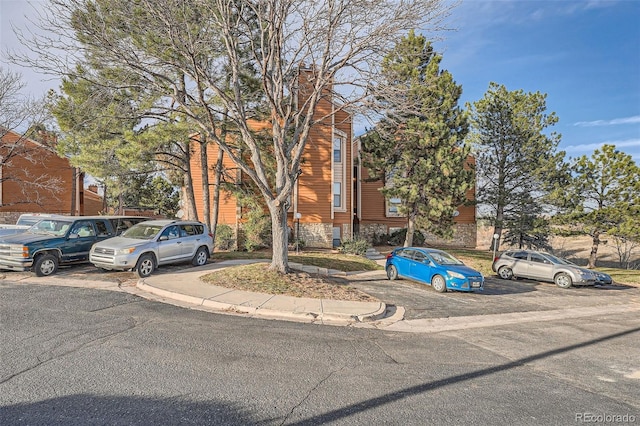 view of front of home with uncovered parking and a chimney