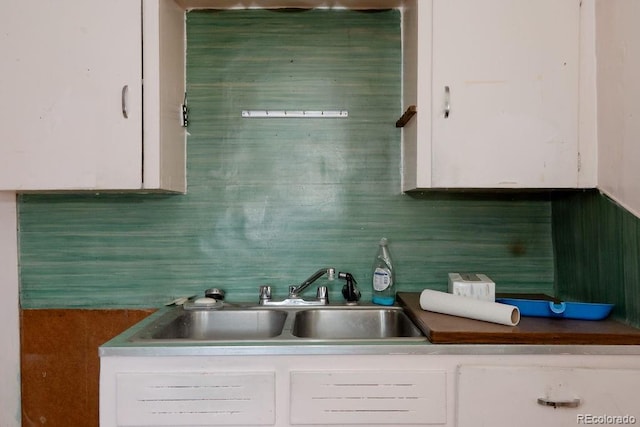 kitchen featuring a sink, white cabinetry, and decorative backsplash