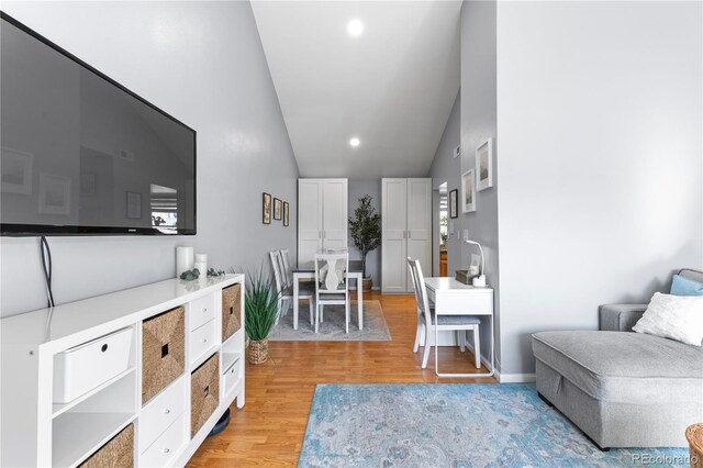 living area with vaulted ceiling and light hardwood / wood-style flooring