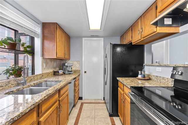 kitchen featuring sink, light tile patterned floors, stainless steel appliances, light stone countertops, and exhaust hood