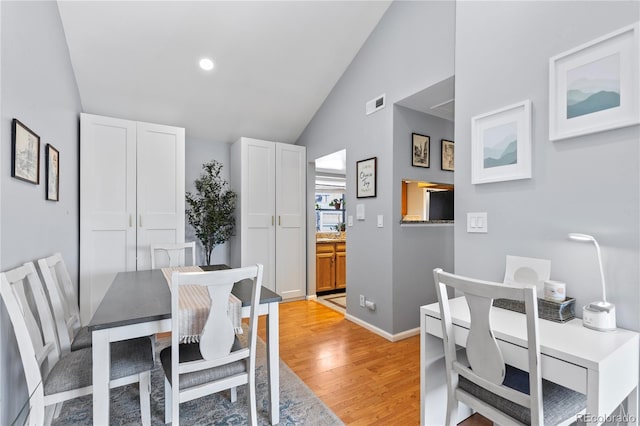 dining room featuring vaulted ceiling and light wood-type flooring