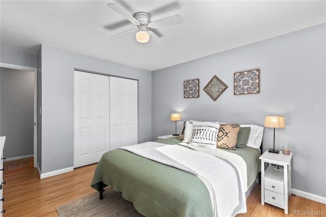 bedroom with light wood-type flooring, ceiling fan, and a closet