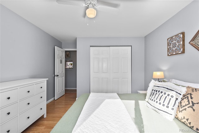 bedroom with light hardwood / wood-style floors, ceiling fan, and a closet