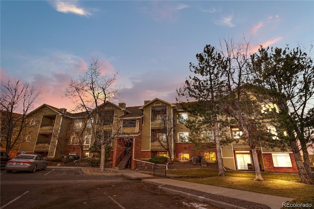 property at dusk with uncovered parking
