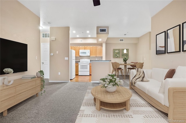 living room featuring recessed lighting, light colored carpet, and baseboards