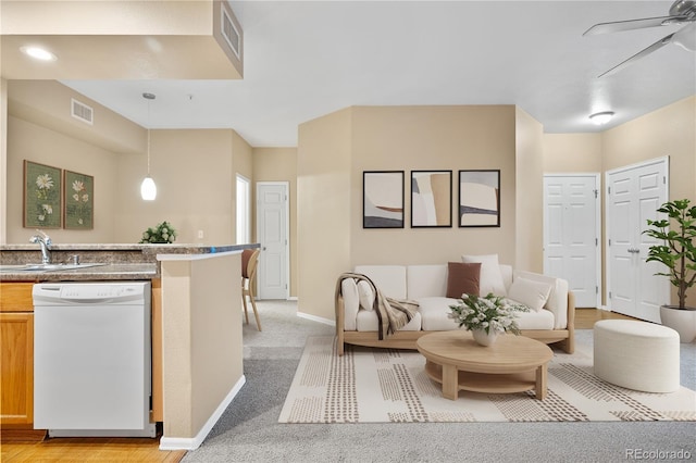 living area with ceiling fan, baseboards, and light carpet