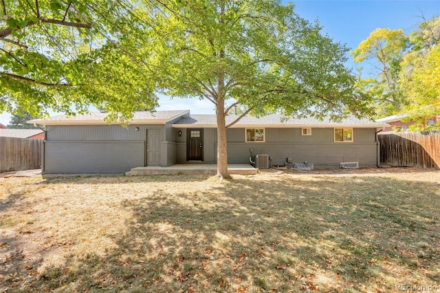 back of house with central AC, a yard, and a patio