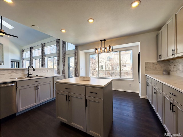 kitchen with backsplash, stainless steel dishwasher, pendant lighting, and a healthy amount of sunlight