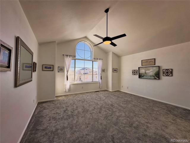 unfurnished living room with ceiling fan, dark colored carpet, and vaulted ceiling