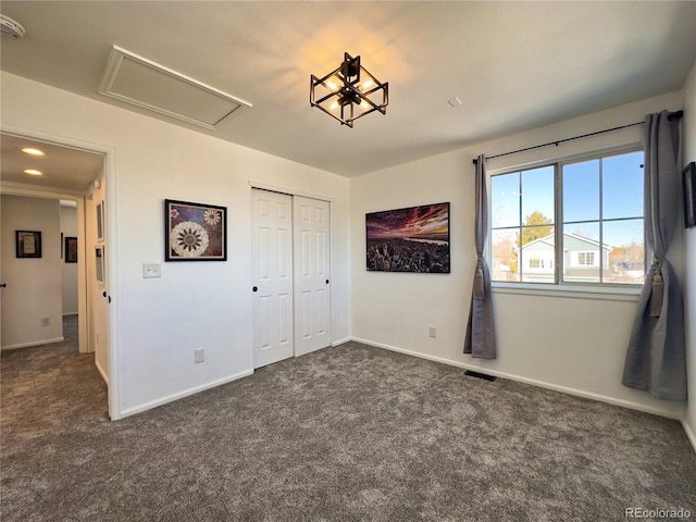 unfurnished bedroom with a closet and dark colored carpet