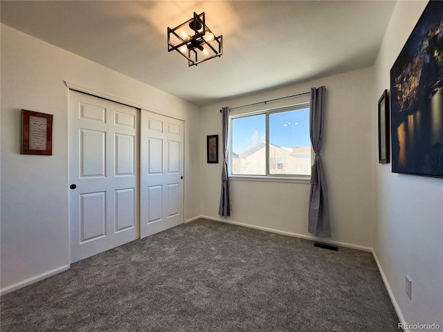 unfurnished bedroom featuring a closet and dark colored carpet