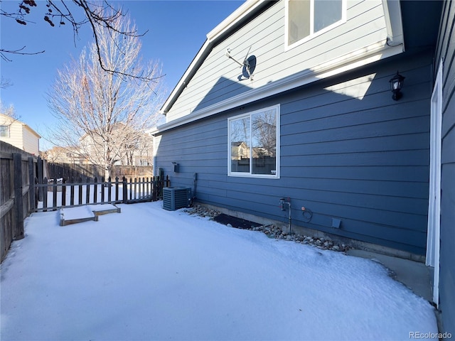 snow covered property featuring central AC