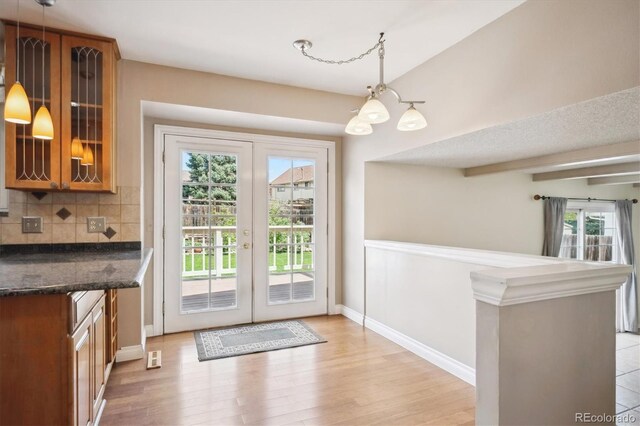 7863 W Quarto Ave, Littleton, CO 80128 - doorway to outside with healthy amount of natural light, light wood-style flooring, baseboards, and a chandelier