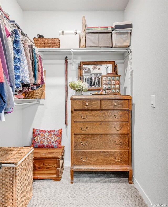 walk in closet featuring light colored carpet