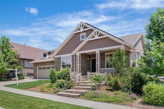27485 E Nova Pl, Aurora, CO 80016 - craftsman house featuring covered porch, stone siding, an attached garage, and driveway