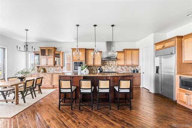 27485 E Nova Pl, Aurora, CO 80016 - kitchen with built in appliances, wall chimney exhaust hood, dark wood-type flooring, a center island with sink, and backsplash