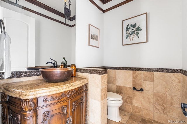 27485 E Nova Pl, Aurora, CO 80016 - bathroom with crown molding, vanity, tile walls, and a wainscoted wall
