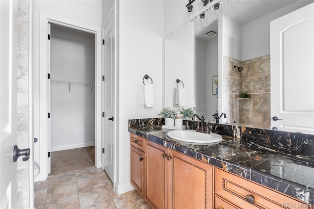 27485 E Nova Pl, Aurora, CO 80016 - bathroom featuring vanity, a tile shower, and a walk in closet