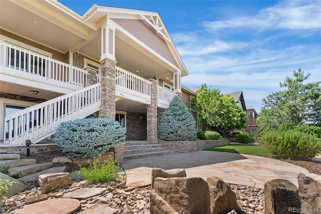 27485 E Nova Pl, Aurora, CO 80016 - view of side of property featuring stairway, a patio area, and stone siding