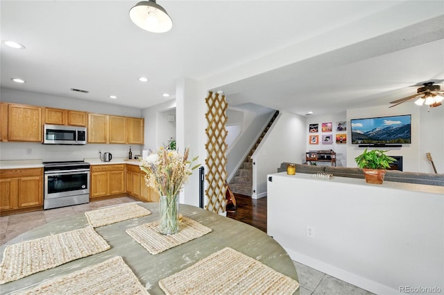 7868 Downing St, Denver, CO 80229 - kitchen with stainless steel appliances, open floor plan, recessed lighting, light countertops, and ceiling fan