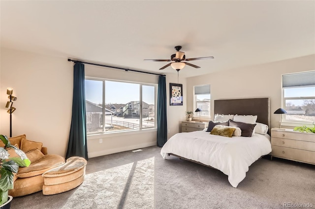 carpeted bedroom with multiple windows and ceiling fan