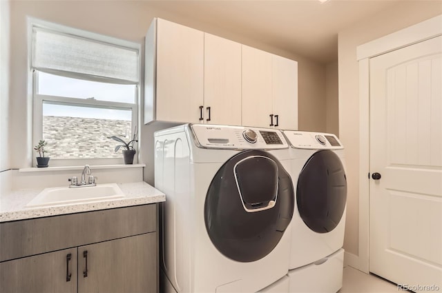 laundry room with cabinets, independent washer and dryer, and sink