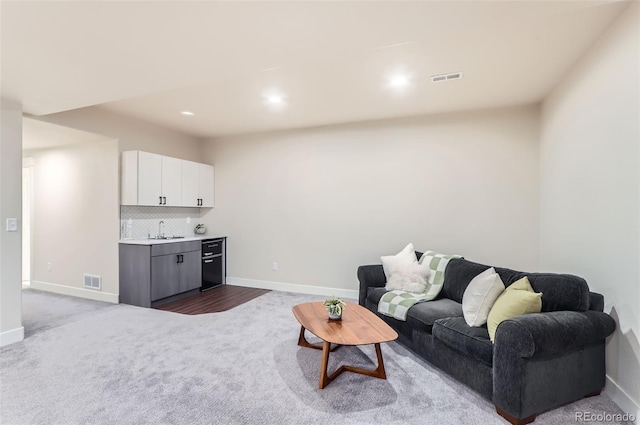 living room featuring sink and carpet flooring