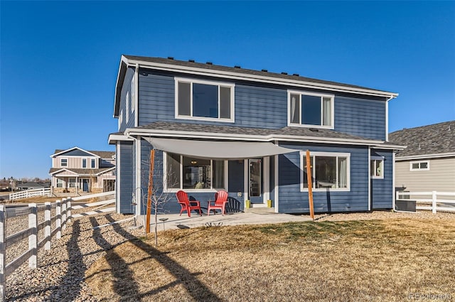 back of house featuring cooling unit, a yard, and a patio