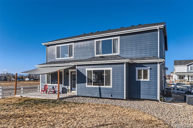 back of property with central AC and a patio area