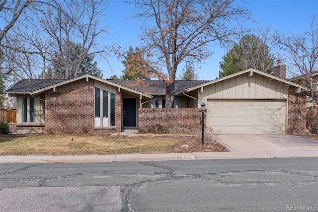 mid-century modern home with brick siding, board and batten siding, a front lawn, driveway, and an attached garage