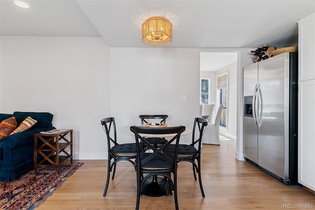 dining area with light wood-style flooring and baseboards