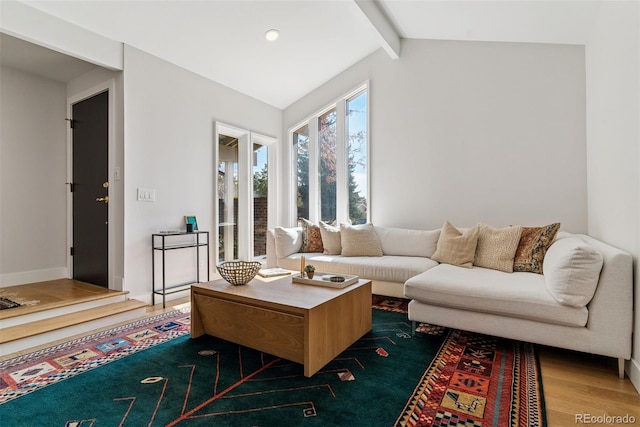 living area featuring vaulted ceiling with beams and wood finished floors