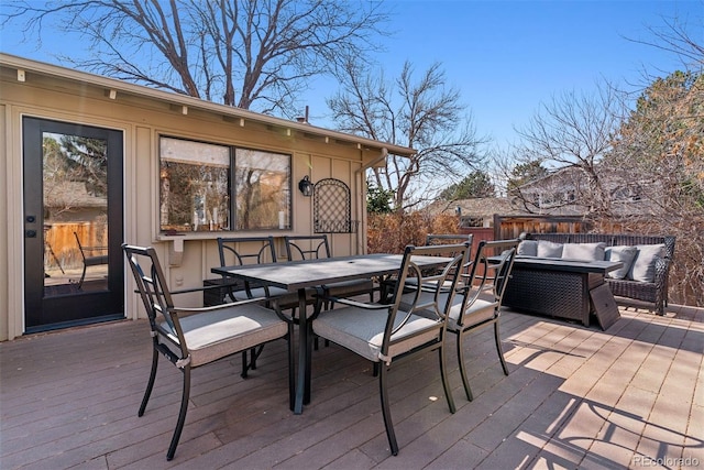 wooden terrace with outdoor dining space and an outdoor hangout area