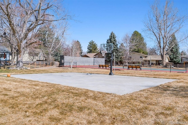 view of sport court featuring a tennis court, a lawn, community basketball court, and fence