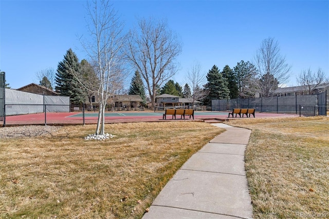 view of community with a tennis court, a lawn, community basketball court, and fence