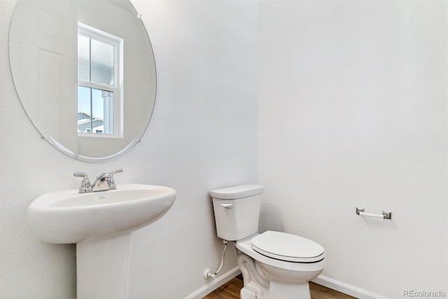 bathroom with hardwood / wood-style floors, toilet, and sink