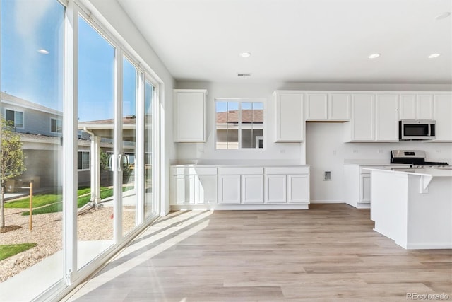 kitchen featuring white cabinetry, stainless steel appliances, and light hardwood / wood-style flooring