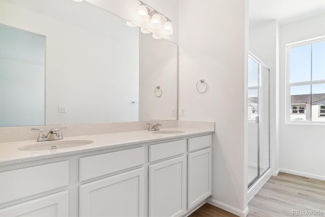 bathroom featuring hardwood / wood-style flooring, vanity, and an enclosed shower