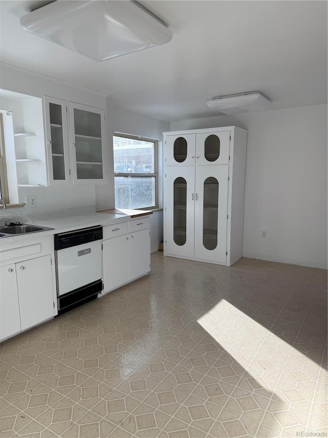 kitchen with dishwasher, sink, and white cabinets