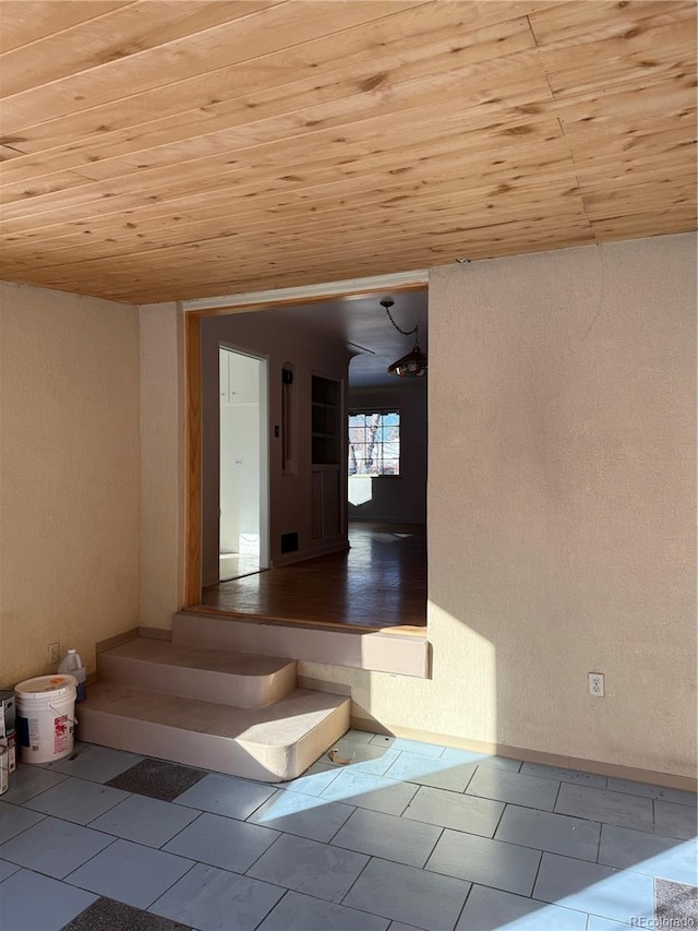 stairway featuring tile patterned flooring and wood ceiling