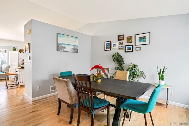 dining area featuring light hardwood / wood-style flooring and vaulted ceiling