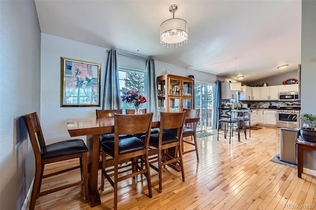 7716 Shenandoah Dr, Elizabeth, CO 80107 - dining area with light wood-style flooring, vaulted ceiling, and baseboards