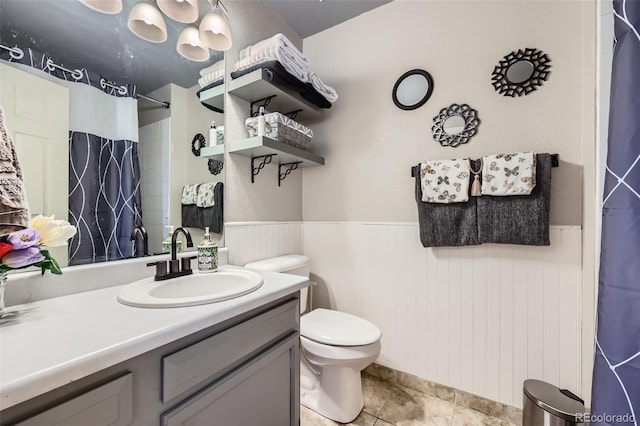 7716 Shenandoah Dr, Elizabeth, CO 80107 - bathroom with a wainscoted wall, toilet, curtained shower, vanity, and tile patterned flooring
