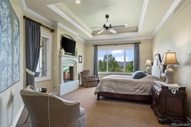 2378 Plumb Pl, Erie, CO 80516 - carpeted bedroom with a tray ceiling, a glass covered fireplace, ornamental molding, and ceiling fan