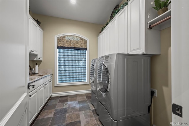 2378 Plumb Pl, Erie, CO 80516 - washroom featuring separate washer and dryer, cabinet space, and dark stone finish floors