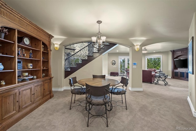 2378 Plumb Pl, Erie, CO 80516 - dining room with arched walkways, light carpet, stairs, and a chandelier